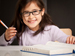 Young girl sitting at desk using a dictionary