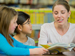 Teacher reading with two schoolgirls