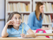 Child at desk thinking carefully