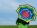 Brightly-colored umbrella against blue sky