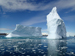 Two icebergs against blue sky and sea