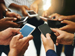 People in a circle holding cell phones