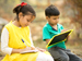 Boy and girl writing and sitting outside