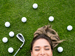 Female golfer lying on grass smiling