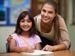 Teacher and girl writing at a desk