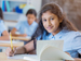 Schoolgirl with research book sitting at desk