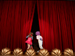 Children peeking through red theater curtains