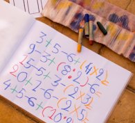 Simple maths and numbers written colourfully in a book